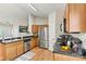 Modern kitchen with stainless steel appliances, wooden cabinets, black countertops, and light wood flooring at 301 N 4Th Ave, Maiden, NC 28650