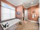 Bright bathroom features a soaking tub with tile surround and ample natural light, perfect for relaxation and spa-like experiences at 810 Lake Wright Rd, China Grove, NC 28023