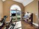 Bonus room featuring a piano, exercise bike, and a large arched window at 810 Lake Wright Rd, China Grove, NC 28023