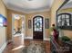 Bright foyer featuring hardwood floors, elegant rug, and doorway to an exercise room at 810 Lake Wright Rd, China Grove, NC 28023