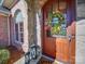 Closeup of wood front door with wreath and sidelight, set in brick and stone entryway at 810 Lake Wright Rd, China Grove, NC 28023