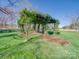 Tranquil outdoor space with an ivy-covered gazebo on a lush green lawn at 810 Lake Wright Rd, China Grove, NC 28023