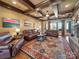 Spacious living room with beamed ceiling, leather sofas, stone fireplace and large windows at 810 Lake Wright Rd, China Grove, NC 28023