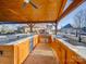 Spacious outdoor kitchen featuring stainless steel appliances, ample counter space, and a covered seating area at 810 Lake Wright Rd, China Grove, NC 28023