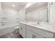 Bright bathroom features a double sink vanity with white cabinets, stone countertops, and tub at 9706 Tea Garden Dr, Gastonia, NC 28056