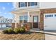 Inviting front porch with stone pillars, manicured bushes, and a secure Vivint alarm system at 9706 Tea Garden Dr, Gastonia, NC 28056