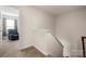 Upstairs hallway with carpet, leading to a bedroom with an armchair at 9706 Tea Garden Dr, Gastonia, NC 28056