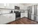 Bright kitchen with stainless steel appliances, granite countertops, white cabinets, and hardwood floors at 9706 Tea Garden Dr, Gastonia, NC 28056