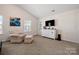 Carpeted main bedroom with a dresser, TV, chair, and ottoman at 9706 Tea Garden Dr, Gastonia, NC 28056