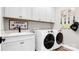 Well-organized laundry room with white cabinets, countertop space, sink, and modern appliances at 1028 Seven Sisters Ave, Monroe, NC 28110