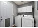 Functional laundry room equipped with white washer and dryer, cabinets and ample space for laundry tasks at 111 Cedar Dr, Salisbury, NC 28147