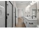 A spacious bathroom featuring a double sink vanity with quartz countertops, black hardware, and a walk-in shower at 113 Homewood Ln, Statesville, NC 28625