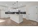 Spacious kitchen with island, white cabinets, stainless steel appliances, and stylish pendant lighting at 113 Homewood Ln, Statesville, NC 28625