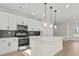 Bright kitchen featuring white cabinets, stainless steel appliances, and a stylish black backsplash at 113 Homewood Ln, Statesville, NC 28625