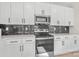 Close up of modern kitchen with white cabinets, stainless appliances and black tile backsplash at 113 Homewood Ln, Statesville, NC 28625