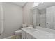 Well-lit bathroom featuring a vanity with a sink, a toilet, and a shower at 118 Alfara Ln, Troutman, NC 28166