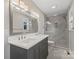 Stylish bathroom featuring a double vanity, a large mirror, and a tiled glass-enclosed shower at 118 Alfara Ln, Troutman, NC 28166