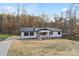 Inviting single-story home with a metal roof, complemented by a well-maintained lawn and natural surroundings at 118 Alfara Ln, Troutman, NC 28166