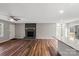 Open-concept living room with a fireplace, ceiling fan, and hardwood floors seamlessly flowing into the adjacent kitchen at 118 Alfara Ln, Troutman, NC 28166