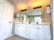 Well-lit bathroom featuring double sinks, a large mirror, and a shower, providing ample space and functionality at 12217 Greymore Ct, Charlotte, NC 28277