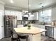 Bright kitchen featuring white cabinets, stainless steel appliances, and an island with seating and stone backsplash at 12217 Greymore Ct, Charlotte, NC 28277