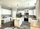 Bright kitchen with white cabinets, stainless steel appliances, and a central island with seating at 12217 Greymore Ct, Charlotte, NC 28277