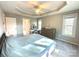 Bright main bedroom featuring a tray ceiling, an abundance of natural light from windows, and a dressing table at 12217 Greymore Ct, Charlotte, NC 28277