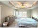 Serene main bedroom with tray ceiling, a large window providing natural light, and a gray dresser, creating a relaxing retreat at 12217 Greymore Ct, Charlotte, NC 28277