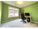 Bright, green home office with gray carpet, large window, and desk with desktop computer at 12217 Greymore Ct, Charlotte, NC 28277