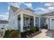 Inviting exterior showcasing a covered front porch with hanging plants, chairs, and beautifully landscaped yard at 126 Sisters Cove Ct, Mooresville, NC 28117