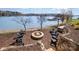 Relaxing lakeside stone fire pit area with seating and a beautiful waterfront view at 126 Sisters Cove Ct, Mooresville, NC 28117