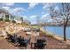 Cozy stone fire pit seating area with waterfront view in a well-manicured backyard at 126 Sisters Cove Ct, Mooresville, NC 28117