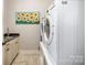 Convenient laundry room with a modern washer and dryer, complemented by stylish decor at 126 Sisters Cove Ct, Mooresville, NC 28117