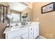 Bathroom featuring double sinks, white cabinets and a large mirror at 134 Cline St, Concord, NC 28027