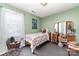 Cozy bedroom with a floral-patterned bed and antique vanity, complemented by ample natural light at 134 Cline St, Concord, NC 28027