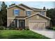 Two-story home with tan siding, gray shutters, a two-car garage, and a well-manicured lawn with colorful flower beds at 134 Shepherds Landing Dr, Mooresville, NC 28115