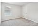 This bedroom offers neutral carpet, a large window, and a closet at 138 Satchel Ct, Mooresville, NC 28115