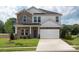 Two-story home featuring a two-car garage, stone facade, and manicured lawn at 142 Shepherds Landing Dr, Mooresville, NC 28115