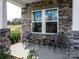 Charming front porch featuring stone accents, two chairs and a table, creating an inviting outdoor space at 142 Shepherds Landing Dr, Mooresville, NC 28115