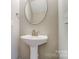 Cozy bathroom with a pedestal sink, an oval mirror, and modern fixtures offers comfort and style at 16729 Timber Crossing Rd, Charlotte, NC 28213