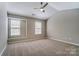 Bright bedroom features neutral walls, carpet, ceiling fan, and large windows at 16729 Timber Crossing Rd, Charlotte, NC 28213