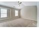 Bright bedroom features neutral walls, carpet, ceiling fan, and large windows at 16729 Timber Crossing Rd, Charlotte, NC 28213