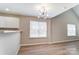 A bright dining area with a modern chandelier, wood-look flooring and a kitchen bar at 16729 Timber Crossing Rd, Charlotte, NC 28213