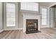 A traditional fireplace with white trim flanked by two sets of patio doors at 16729 Timber Crossing Rd, Charlotte, NC 28213