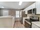 Modern kitchen featuring white cabinets, stainless steel appliances, and laminate flooring at 16729 Timber Crossing Rd, Charlotte, NC 28213