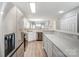 Modern kitchen with stainless steel appliances, white cabinets, light countertops, and wood-look flooring at 16729 Timber Crossing Rd, Charlotte, NC 28213