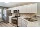 Modern kitchen featuring white cabinets, stainless steel appliances, and laminate flooring at 16729 Timber Crossing Rd, Charlotte, NC 28213