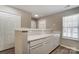 Bright kitchen featuring a serving bar with white cabinets and light countertops and flooring at 16729 Timber Crossing Rd, Charlotte, NC 28213