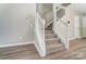 Carpeted staircase with white railings and wood floors provides a seamless transition between floors at 16729 Timber Crossing Rd, Charlotte, NC 28213