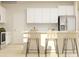 Bright kitchen featuring white cabinets, stainless steel appliances, and three woven bar stools at 1816 Otter Perch Ln, Fort Mill, SC 29715